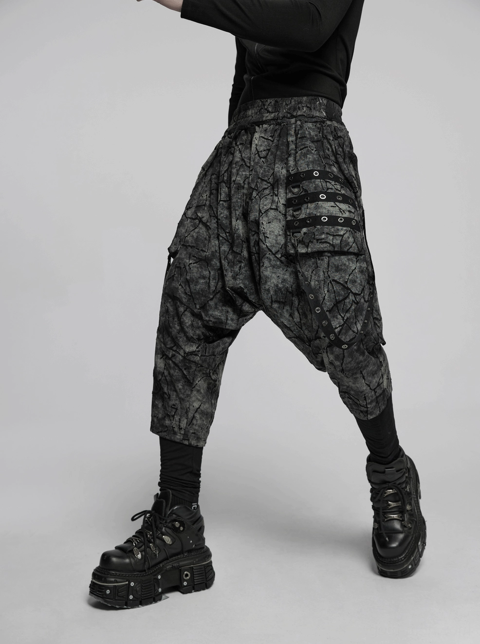 Black tie-dye gothic harem pants detail view showing eyelet strap construction and cracked fabric texture