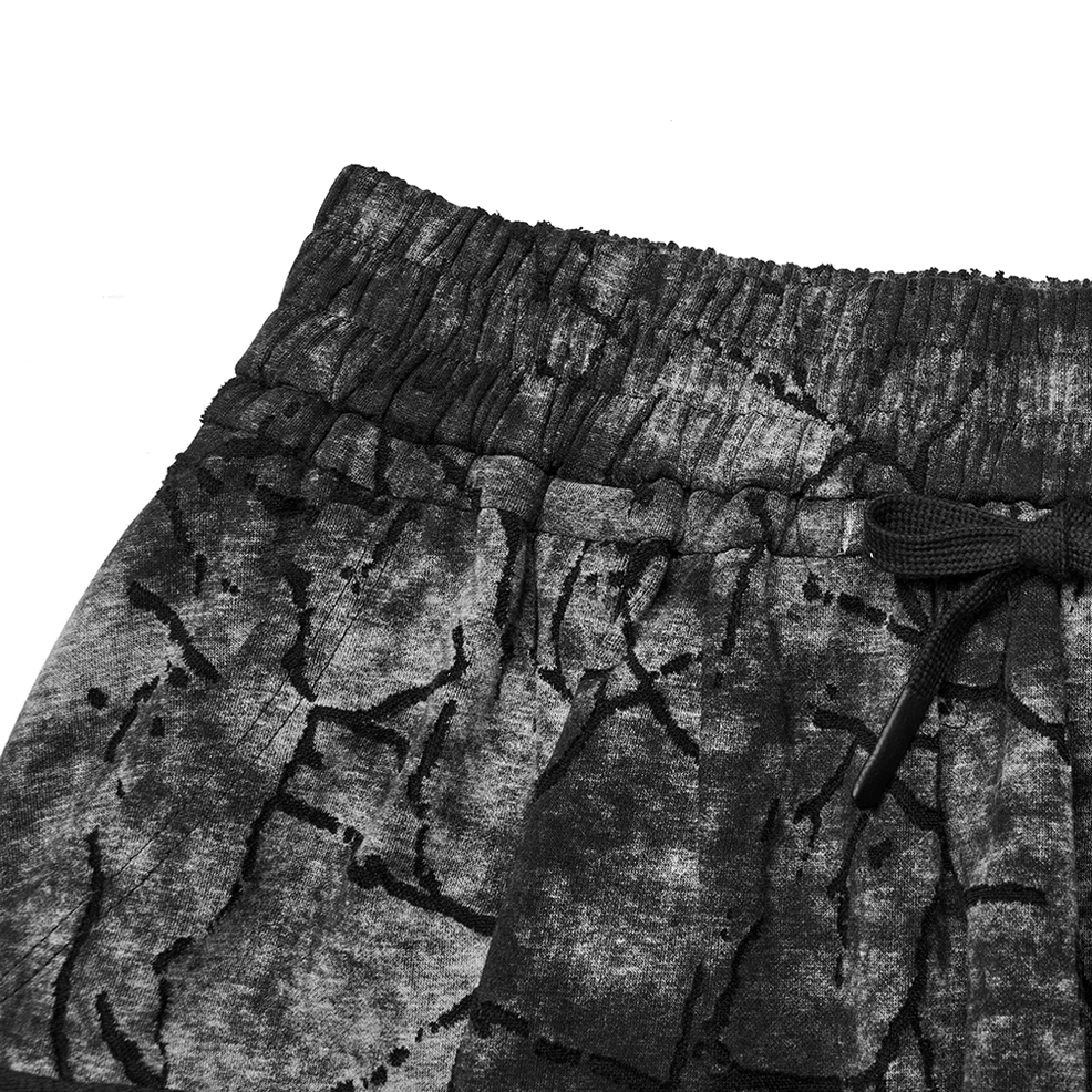 Close-up detail of black tie-dye harem pants waistband with elastic band and drawstring closure
