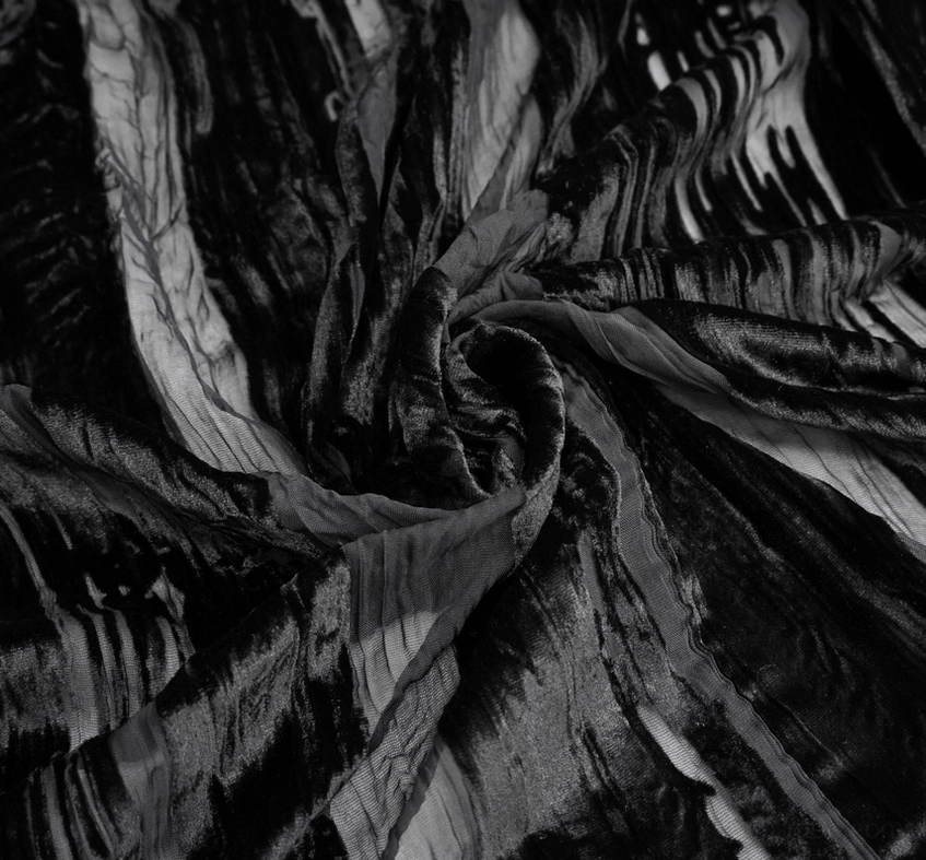 Twisted flat lay close-up of crinkled sheer velvet fabric with wavy stripe texture in darkness