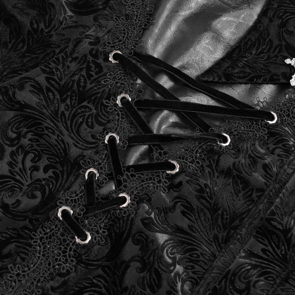 Macro close-up of black velvet lace-up front detail showing metal eyelets, embroidered floral base fabric, and lace straps