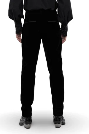 Rear full-body view of fitted black velvet gothic trousers showing tailored waist and slim-cut silhouette
