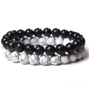 Black and white natural stone beaded bracelet with polished jet beads and white howlite accents, flat lay top view