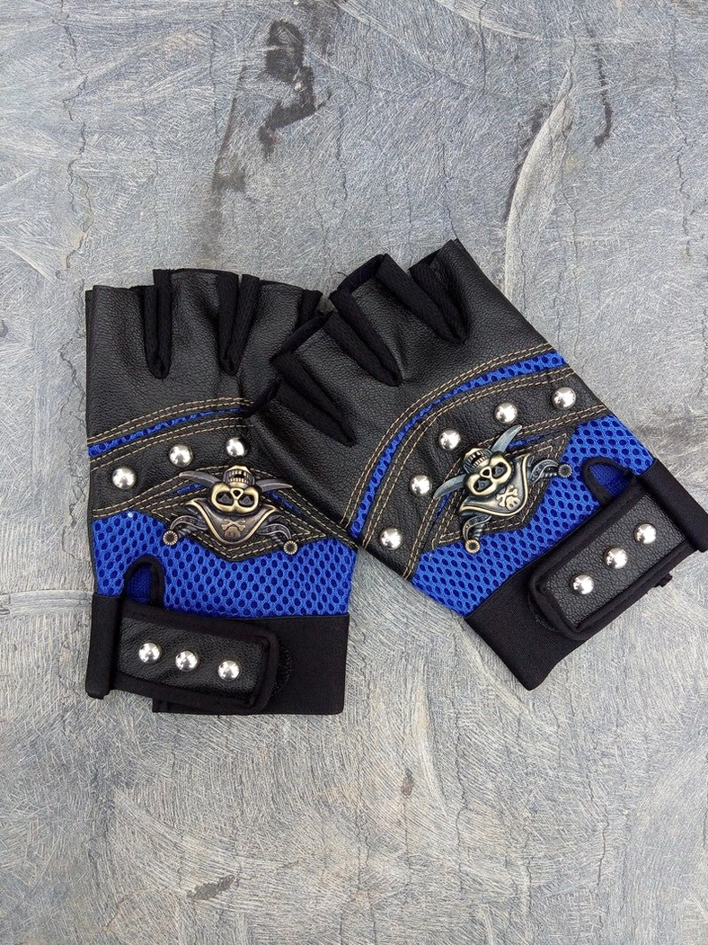 Blue mesh fingerless gloves with velcro studded wrist strap and skull decor on stone texture background angled top-down