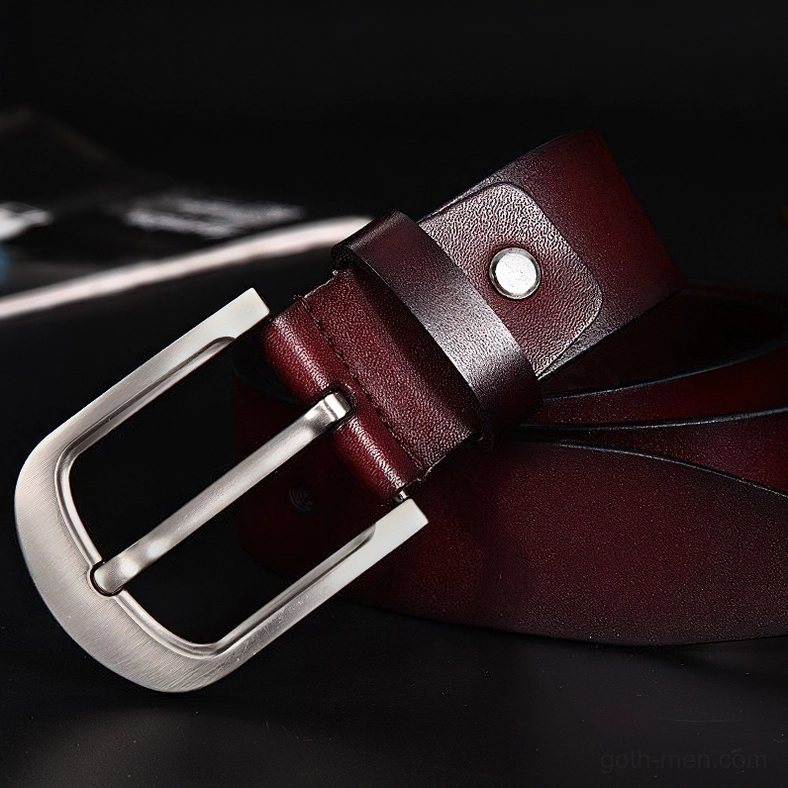 Brown cowhide leather belt with matte silver buckle, 3/4 overhead perspective on dark background