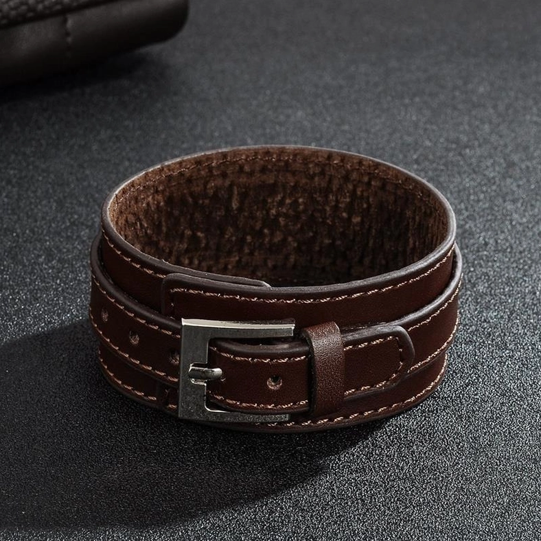Brown leather gothic cuff bracelet featuring gunmetal buckle and soft fuzzy inner lining, flat lay detail shot