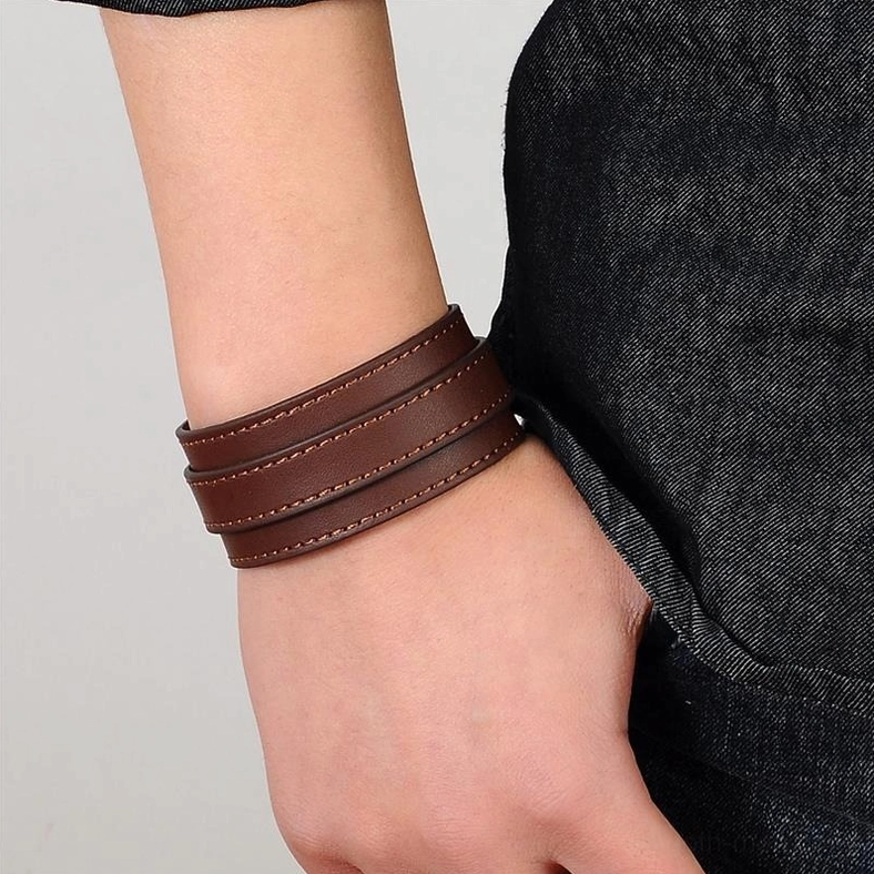 Brown stitched gothic leather cuff bracelet on wrist, fitted adjustable design, styled wear demonstration