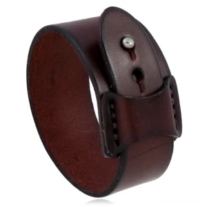 Brown vintage leather wide cuff bracelet with matte cowhide finish and metal buckle strap, flat lay photography