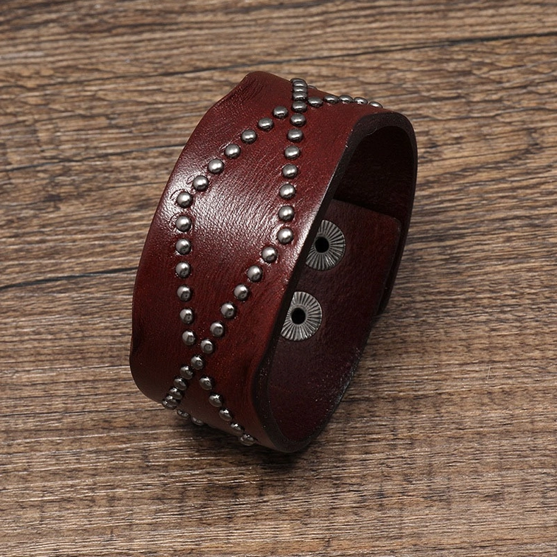 Dark brown leather gothic cuff bracelet showing side profile with industrial rivet texture and snap closure