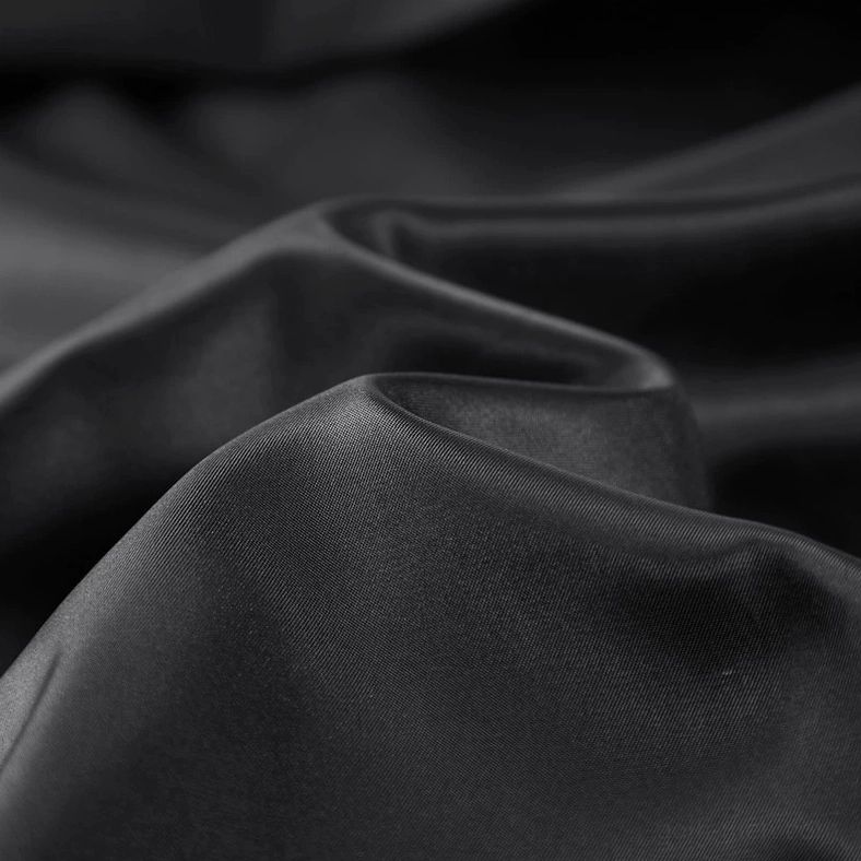 Close-up detail of camouflage PU leather bomber jacket matte black satin inner lining showing soft wrinkle texture and premium finish