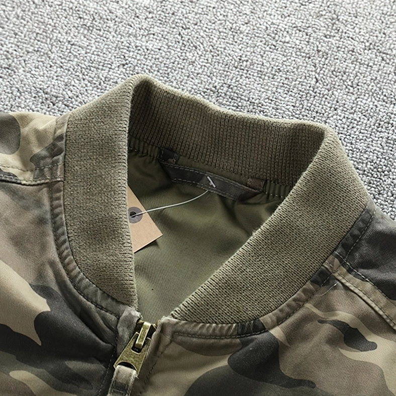 Close-up of metal zipper puller and inner brand tag on camo denim jacket, ribbed knit collar detail photography