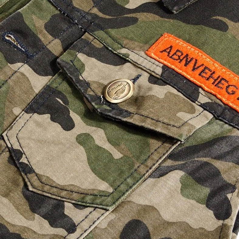Embroidered badge patch and metal branded button on goth denim vest pocket