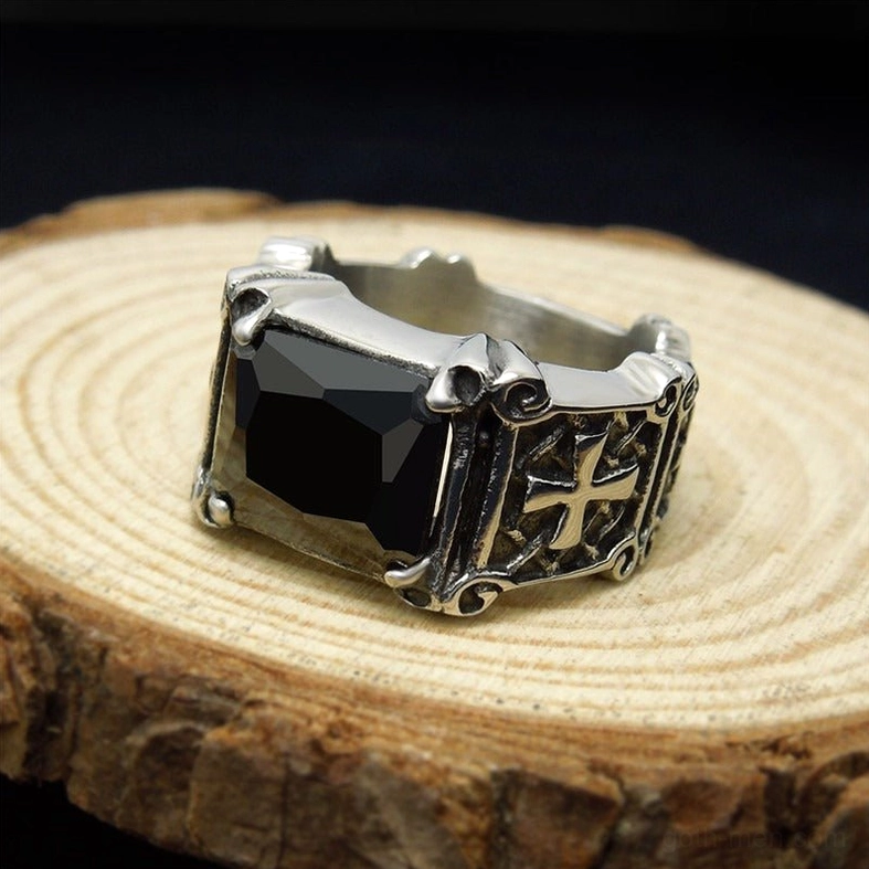 Black gem celtic cross ring on wooden display, top oblique angle showing engraved cross details and vintage silver tone stainless steel