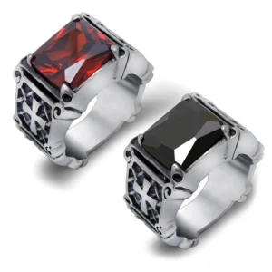 Celtic cross stainless steel rings with red and black gemstones, overhead view showing geometric carved details and tension stone settings