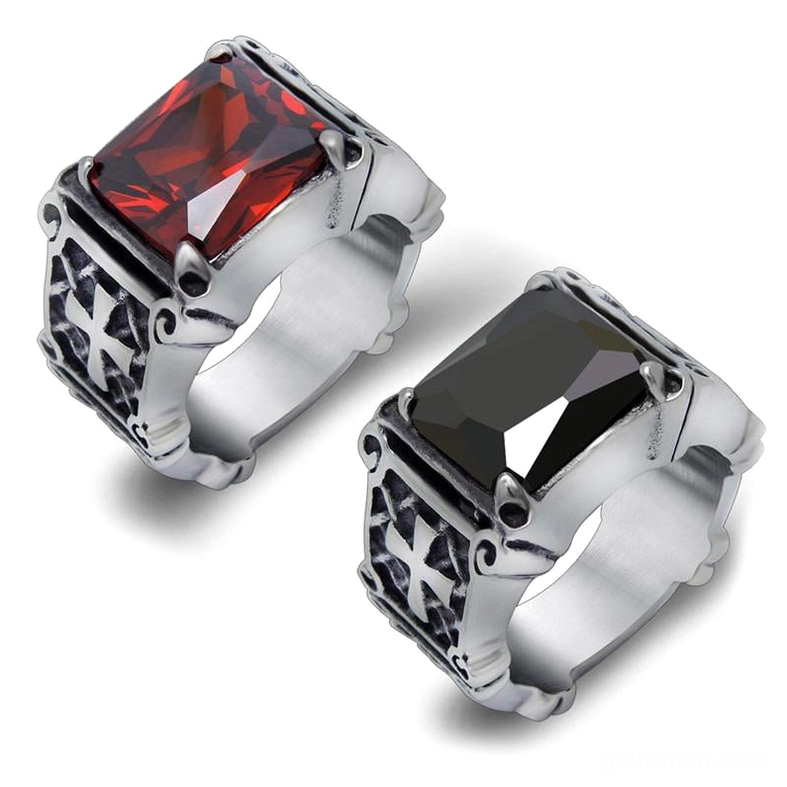 Celtic cross stainless steel rings with red and black gemstones, overhead view showing geometric carved details and tension stone settings