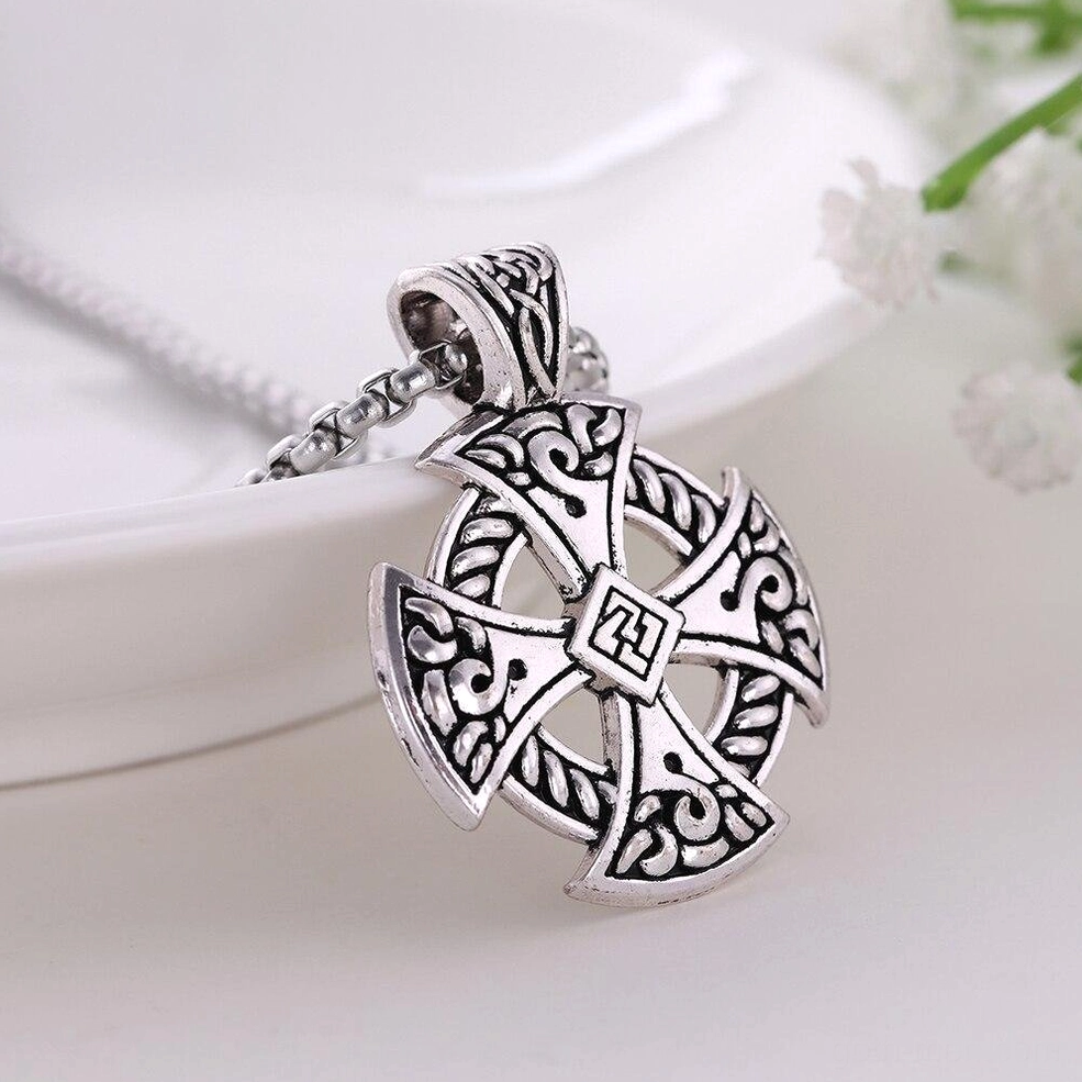 Gothic Celtic cross necklace with wheat link silver chain, styled with vintage accessories and white flowers background