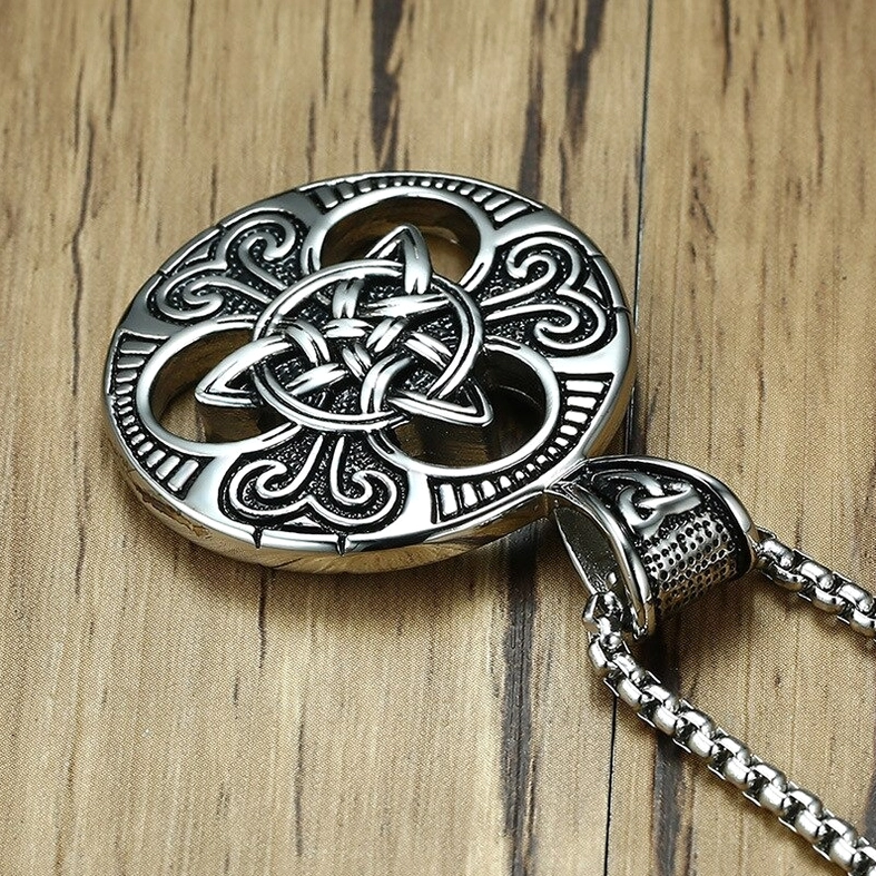 Celtic knot pendant and detached chain stainless steel flat lay wooden background