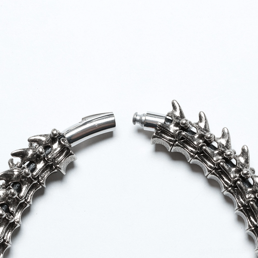 Magnetic push-lock clasp close-up featuring vertebrae-matching design and secure snap fastener in aged silver finish