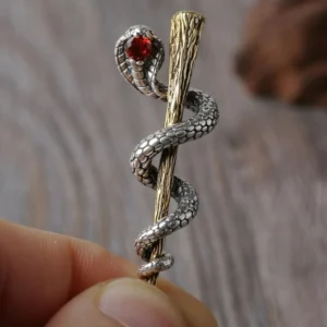 Detailed close-up of gothic cobra pendant held in hands showing scaled texture and bronze staff - alternative jewelry detail