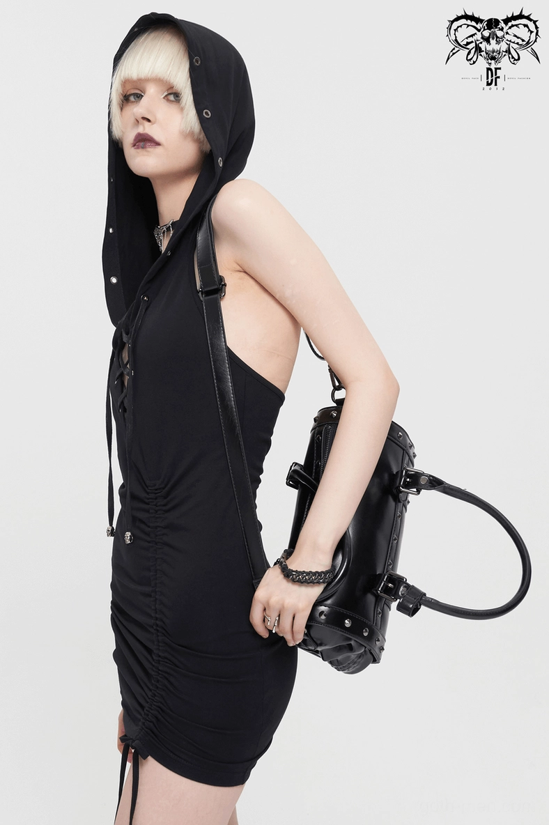 Goth model in backless hooded dress wearing gothic skull rivet bag as crossbody style with metal rivets visible