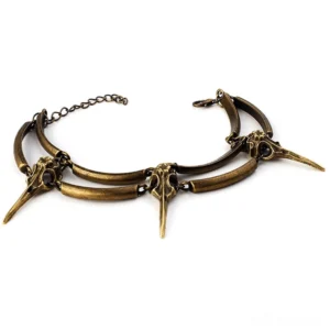 Antique crow skull chain bracelet flat lay showcasing detailed bone-shaped pendants and adjustable link chain in aged bronze finish