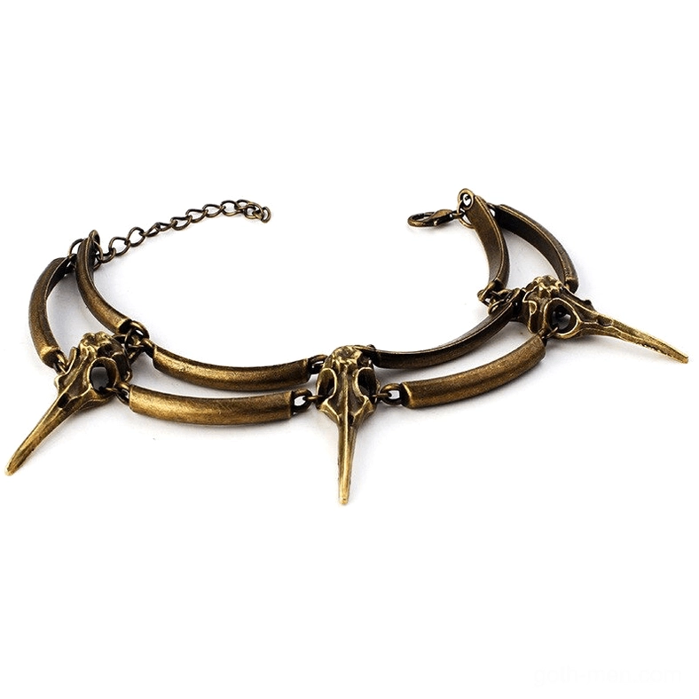 Antique crow skull chain bracelet flat lay showcasing detailed bone-shaped pendants and adjustable link chain in aged bronze finish