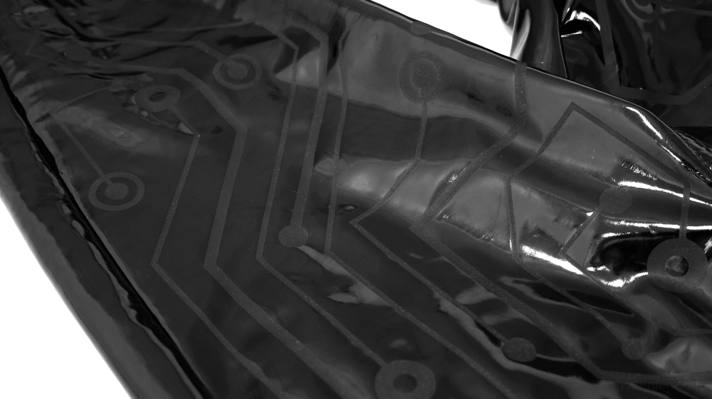 Circuit board print pattern on black glossy PU leather fabric close-up detail shot