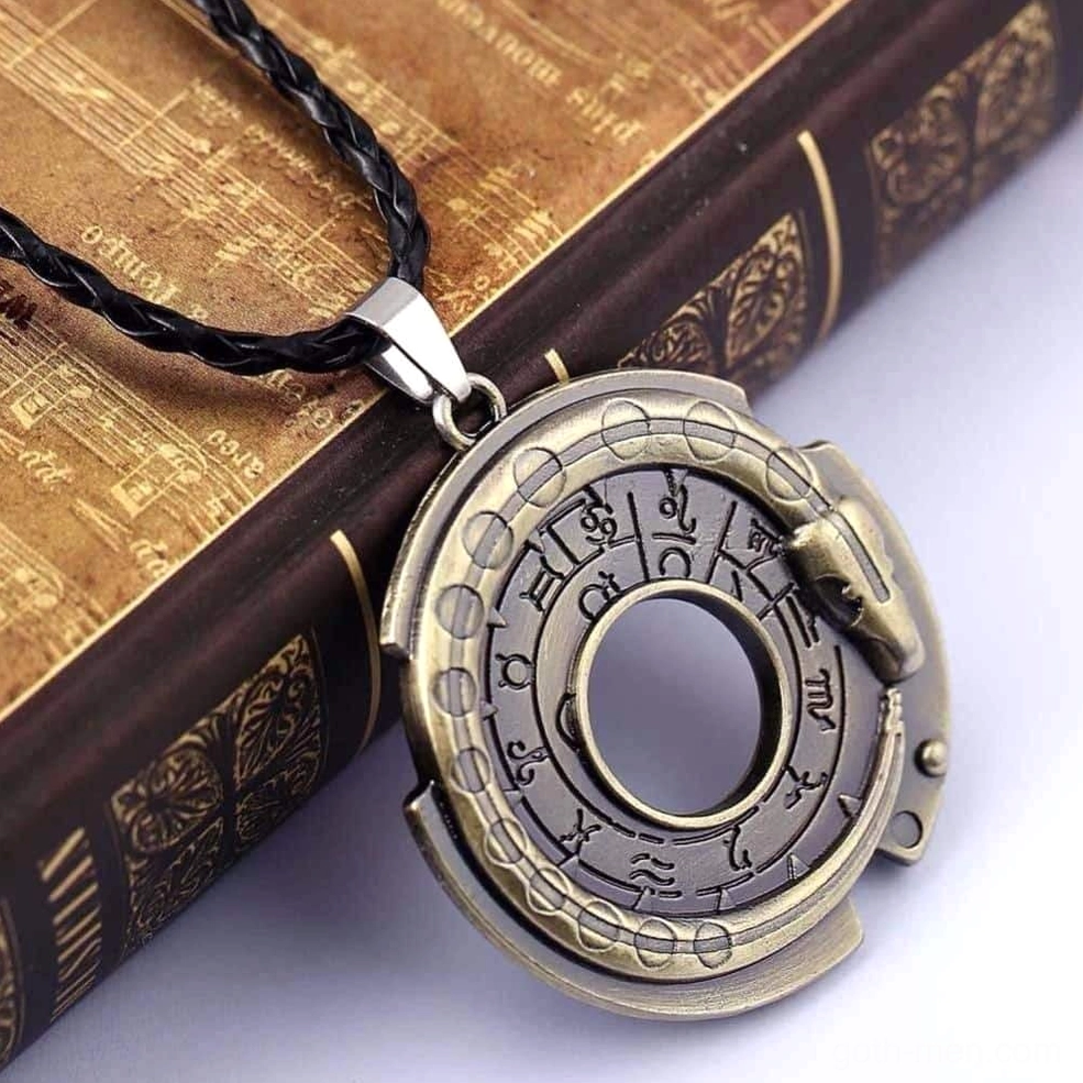 Serpent rune gothic necklace photographed on vintage hardcover book, braided leather cord with engraved constellation patterns and snake accent