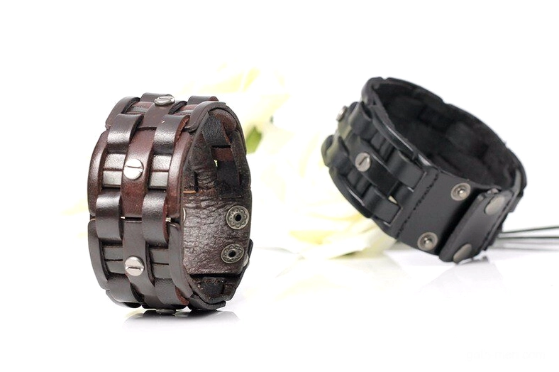 Two gothic leather wrap bracelets in dark brown and black, flat lay with white floral styling, side view showcasing woven texture