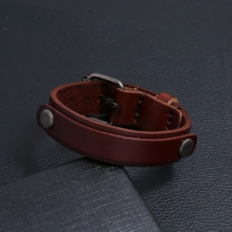 Dark brown genuine leather gothic cuff bracelet wrapped design with metal hardware on textured leather background
