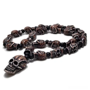 Dark brown aged skull bead gothic necklace with matte black spacers and large skull pendant on white background