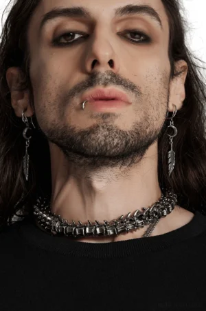 Anatomical spine choker worn by male model, frontal close-up showing detailed vertebrae links and aged silver finish against neck