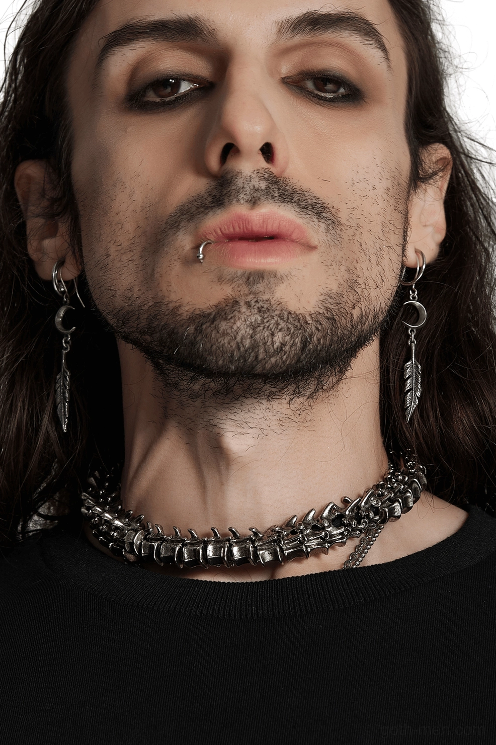 Anatomical spine choker worn by male model, frontal close-up showing detailed vertebrae links and aged silver finish against neck