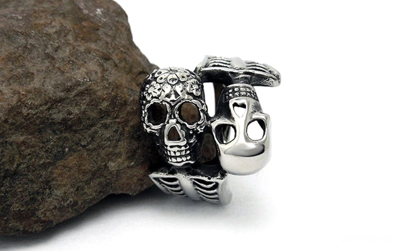 Skull statement ring on rock surface showing design depth and texture details