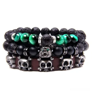 Dark trinity layered gothic bracelet stack with natural stone beads, skull charms, wolf pendant, and vintage braided leather straps on white background