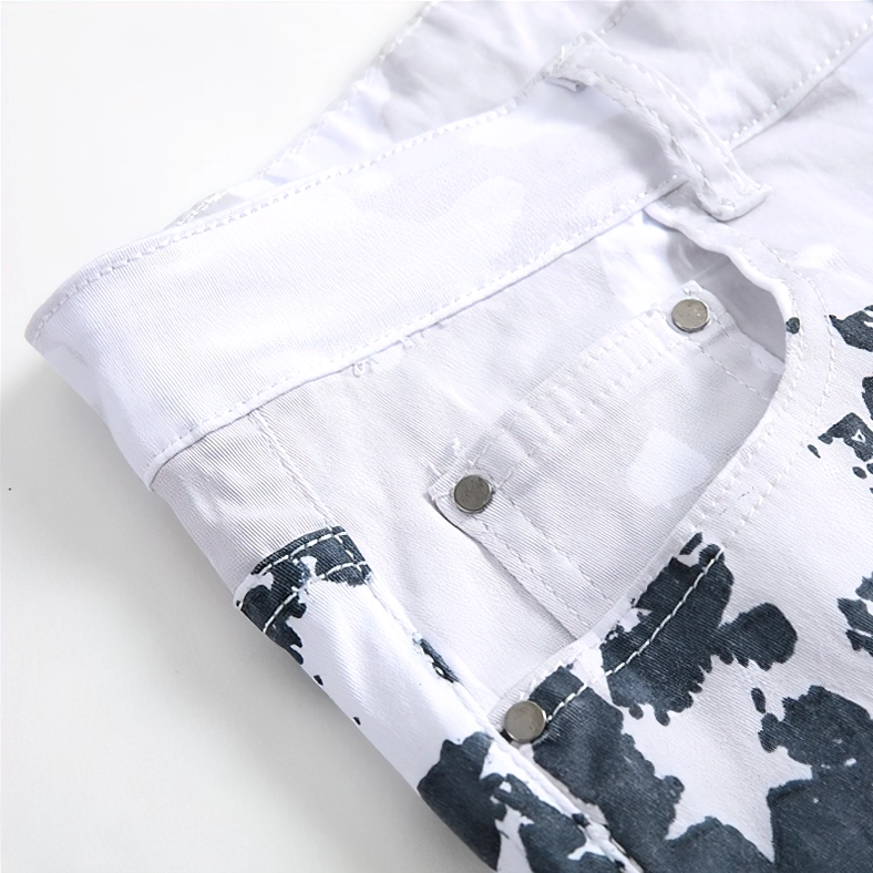 Close-up detail shot of metal stud fasteners and star-patterned white denim fabric on jeans construction