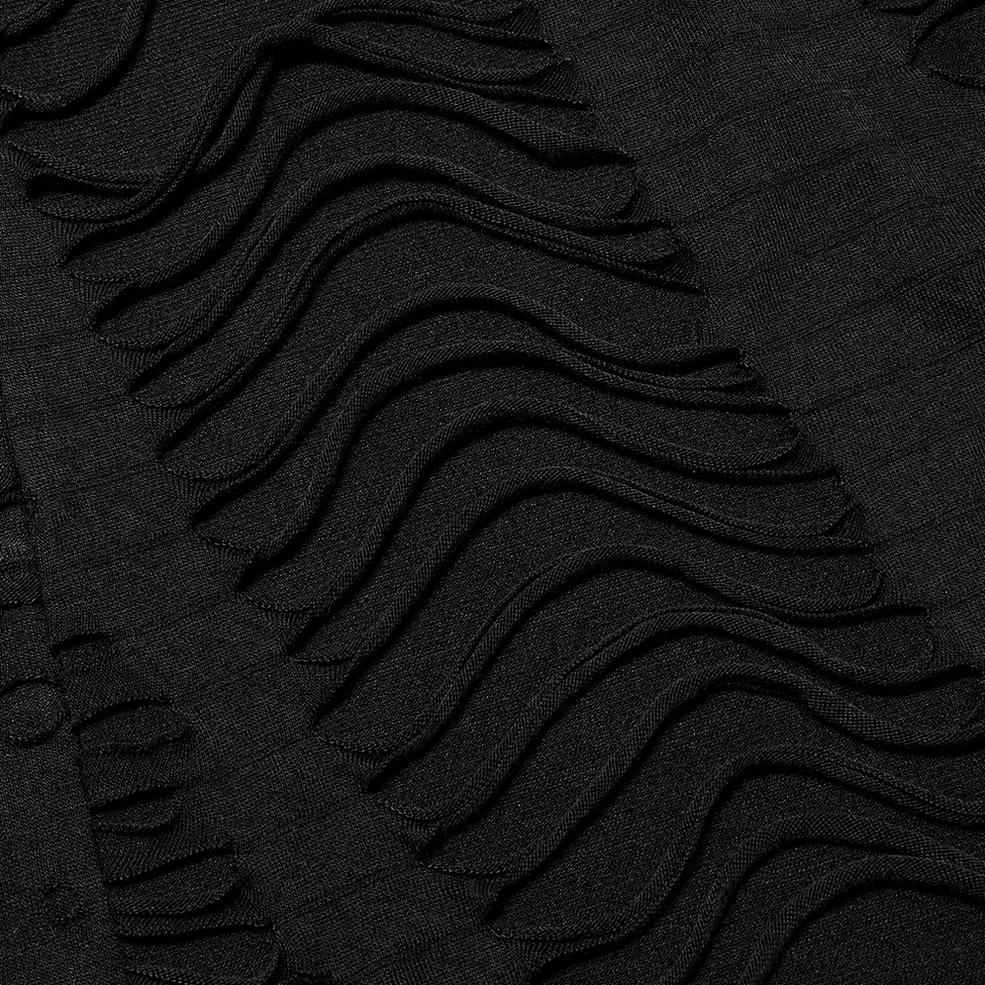 Macro close-up texture of black destructed knit sweatshirt showing wavy ripped knitted fabric and destruction pattern