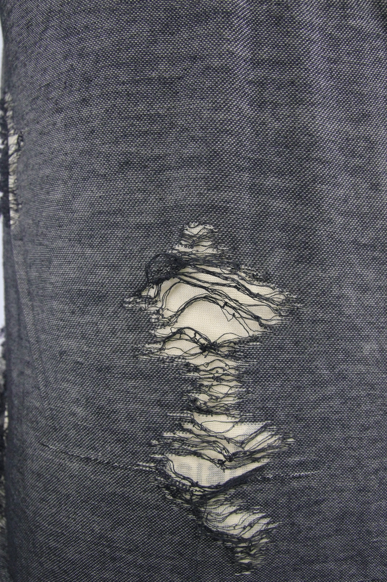 Flat lay of distressed gothic tank top displaying crisscross lacing, irregular holes, and black shoulder panel
