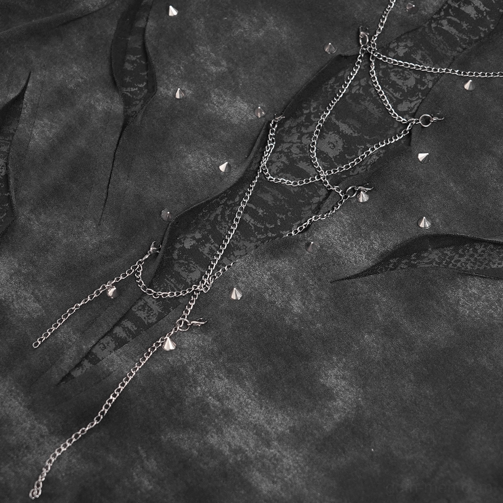 Macro detail shot of metal chains and pyramid studs on distressed ripped fabric panels