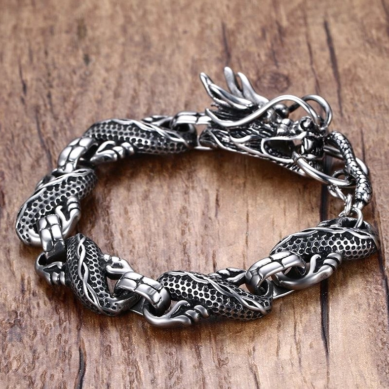dragon stainless steel bracelet full close-up view wooden table carved dragon head prominent link detail
