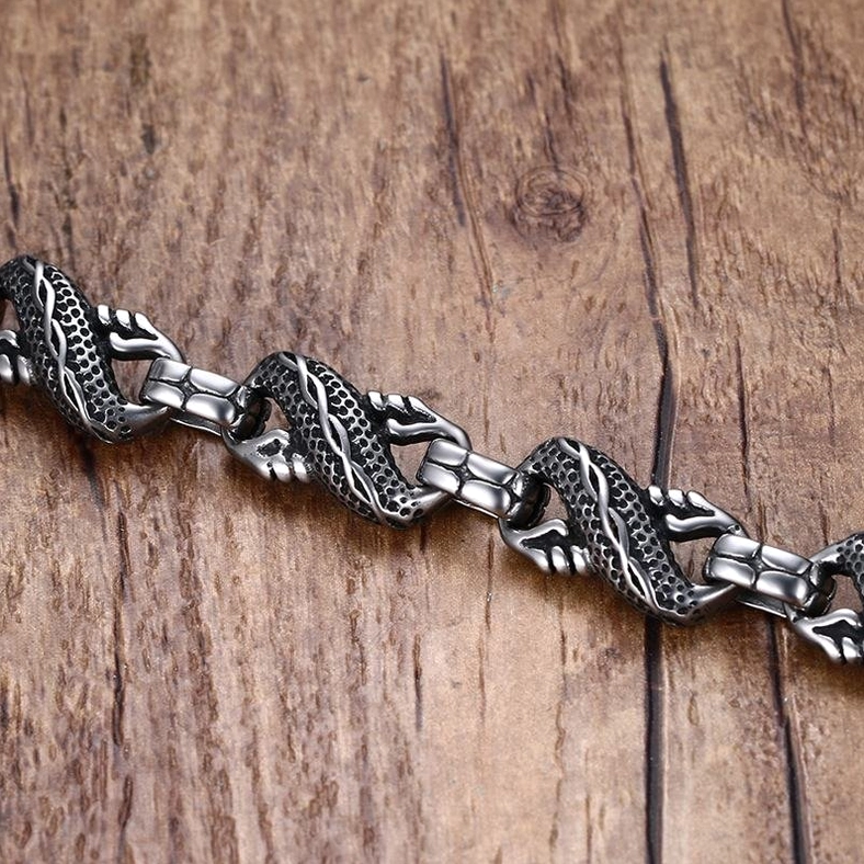 dragon stainless steel bracelet chain segments side flat lay wooden background interwoven engraved links