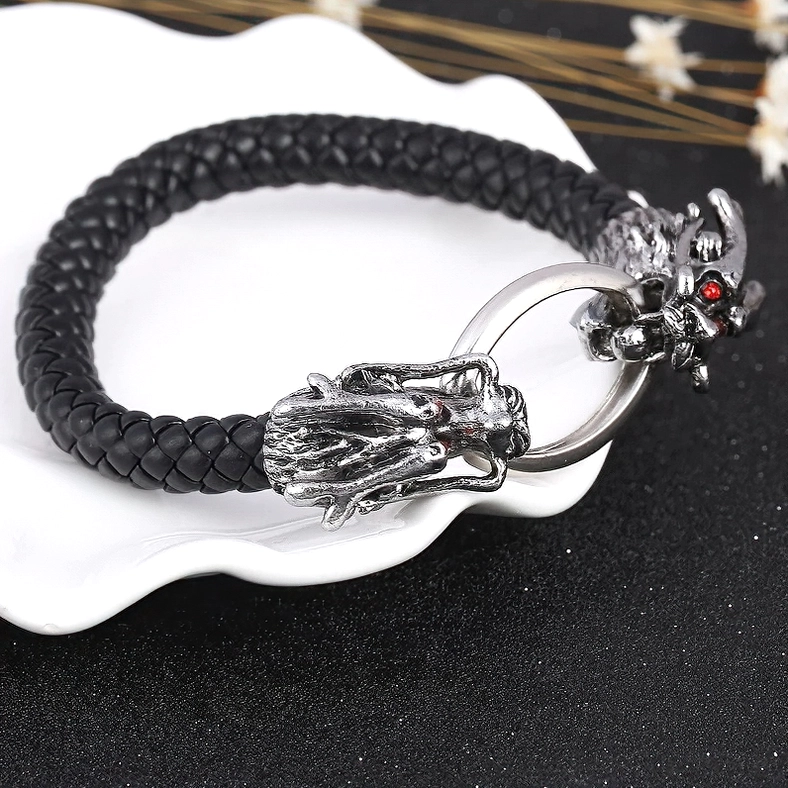 Dragon head punk leather bracelet with red gem eyes on white ceramic tray - three-quarter flat lay display