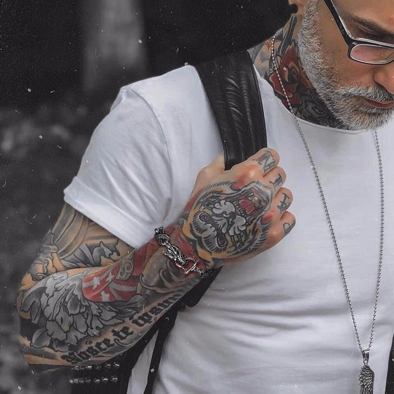 tattooed man hand close-up wearing dragon stainless steel bracelet casual street wear punk style