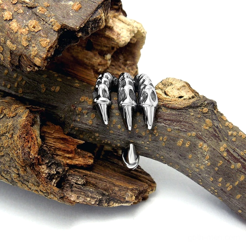 Gothic dragon claw biker ring placed on wooden branch showing silvered finish and vintage aesthetic