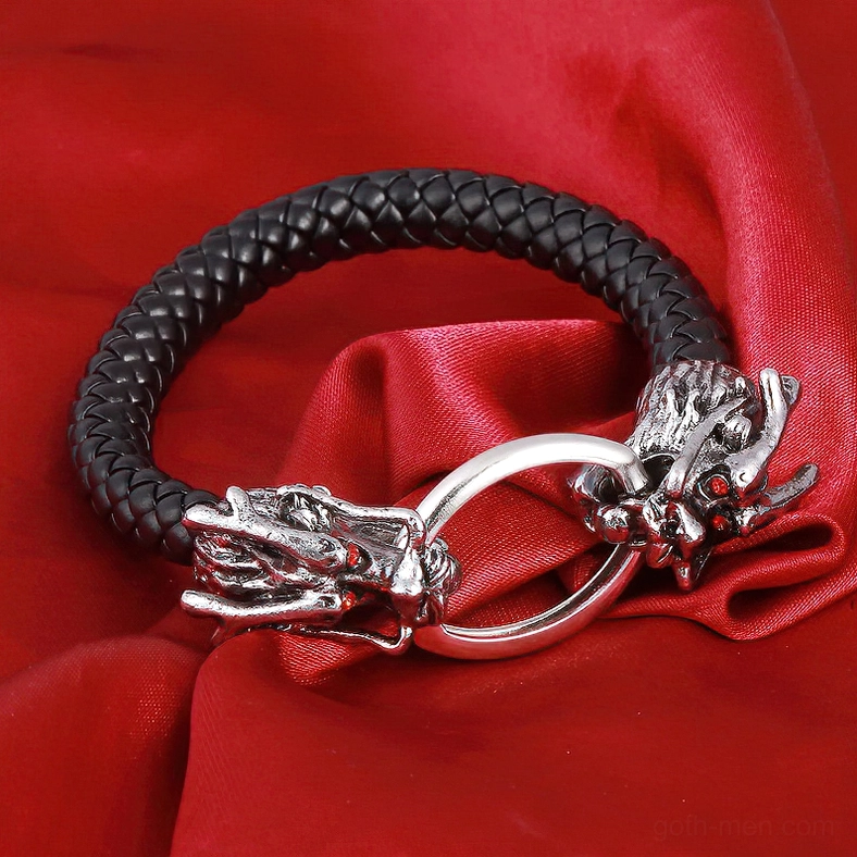 Dragon head punk bracelet with red gemstone accents on red satin fabric - overhead flat lay studio shot