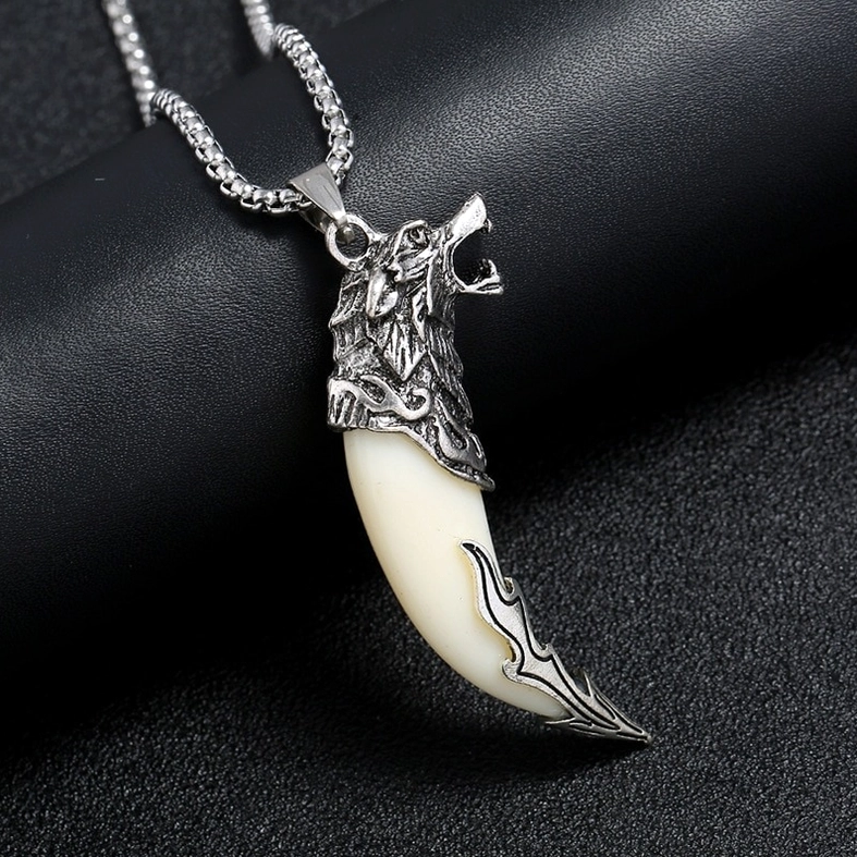 gothic wolf tooth pendant necklace close-up side view dragon head metal cap on leather background