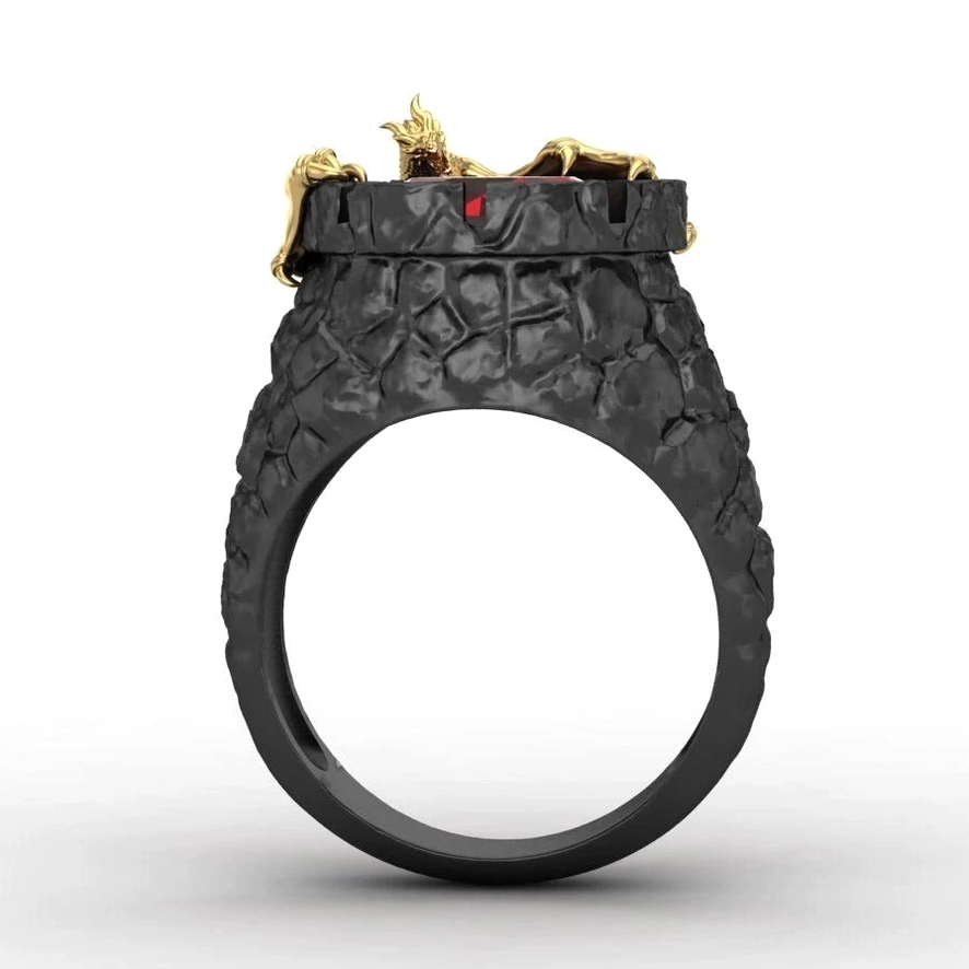 Top-down view of gothic dragon accent ring with tiny golden dragon and red gem on cracked black band