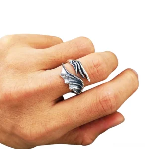 Adjustable dragon wing open ring worn on human hand, front close-up view displaying dual wing design with aged dark accents