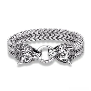 Dual wolf head stainless steel gothic bracelet with wheat link chain, polished silver finish, flat lay top-down view on white background