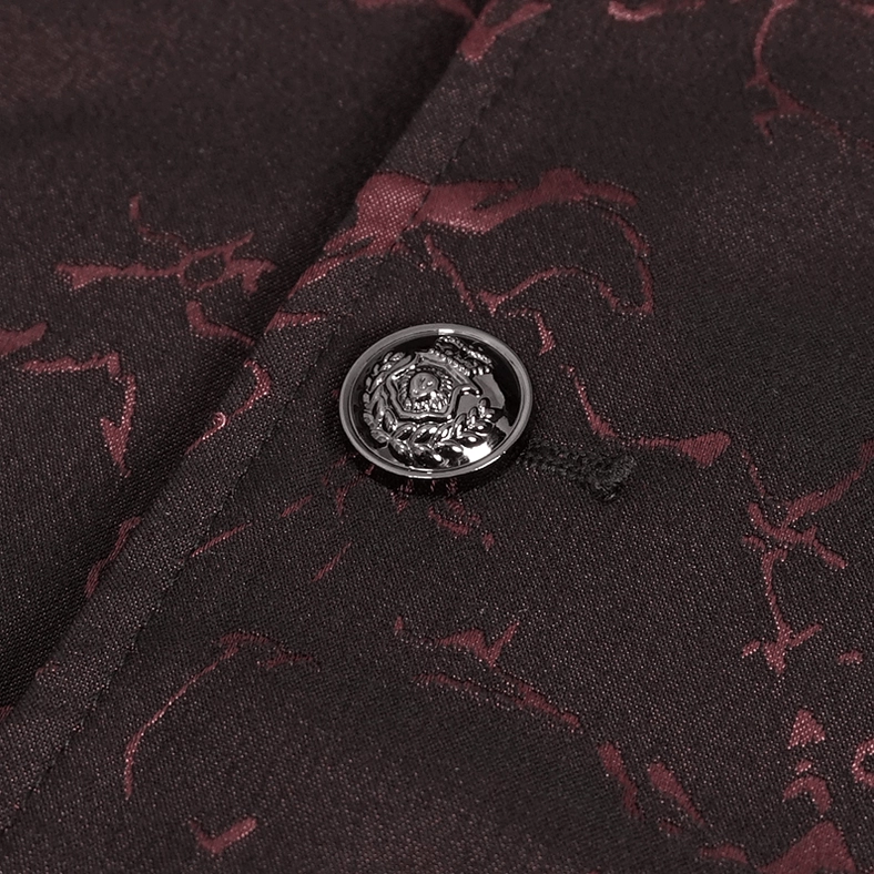 Macro close-up of embossed rose pattern metal button on wine red jacquard tailcoat fabric
