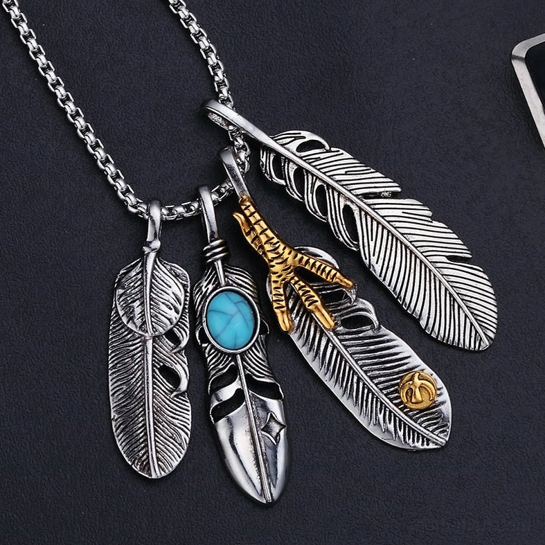Feather claw pendant necklace with mixed feather styles, gold-tone decoration, and turquoise stone on black matte background